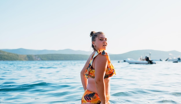 A fat woman enjoys the sea at sunset Selective focus