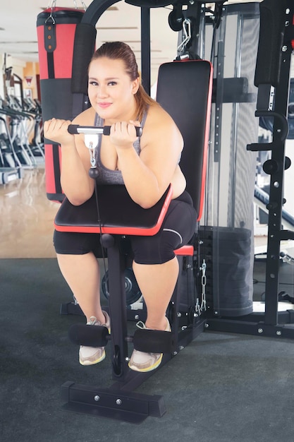 Fat woman exercising her biceps