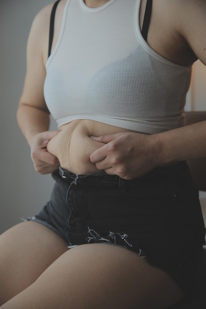 Фото Толстая женщина толстый живот пухлая тучная женщина рука держит чрезмерный жир на животе с мерной лентой женщина диета образ жизни концепция