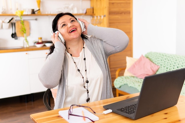 Photo a fat woman is sitting at a table with a laptop