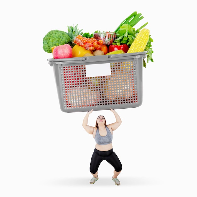 Fat woman lift a box full of vegetables and fruits