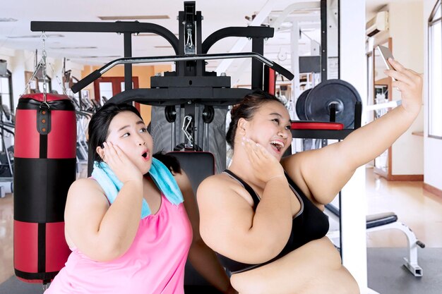 Fat women taking picture in the gym center