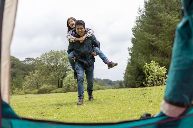 写真 フィールドのキャンプで楽しんでいる父と娘