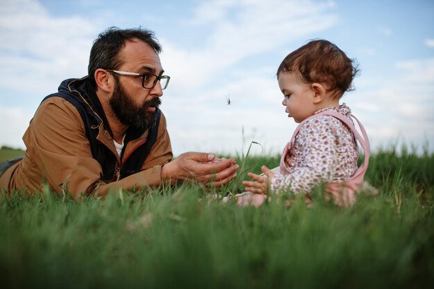 Фото Отец и дочь на траве на фоне неба