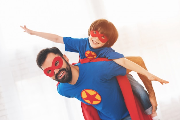 사진 아버지와 아들은 슈퍼 히어로 얼굴 마스크를 착용하고 있습니다.