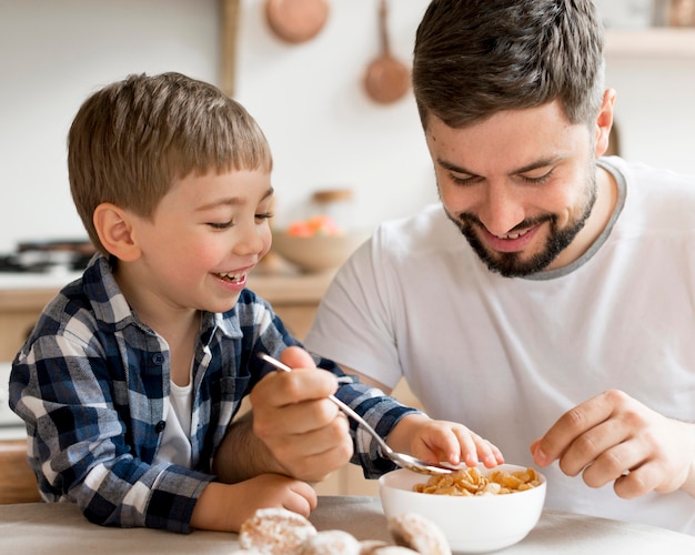 写真 朝食にシリアルを食べる父と息子