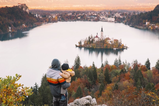 사진 슬로베니아 유럽의 블레드 호수 가을 또는 겨울의 멋진 전망을 감상하며 일몰을 바라보는 아버지와 아들