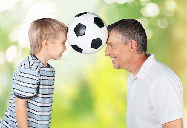Фото Отец и сын играют с футбольным мячом на заднем плане