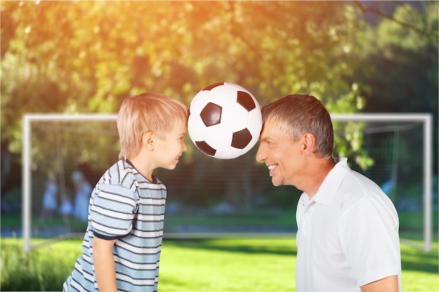 Фото Отец и сын играют с футбольным мячом на открытом воздухе