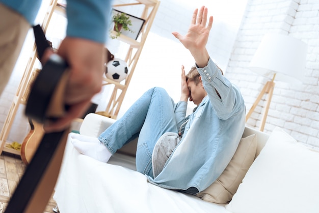 Foto il padre si avvicina al figlio con la cintura che lo ha colpito.