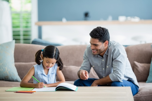 Father assisting her daughter in doing her homework