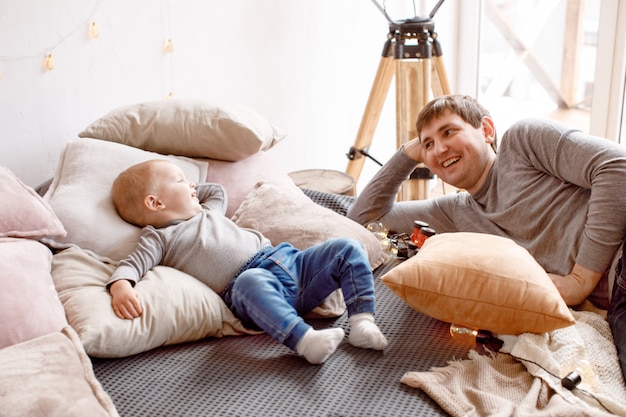 Father and baby lying on bed