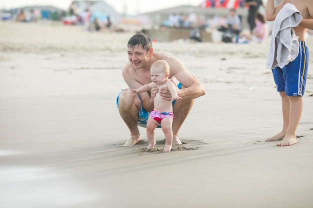 海で泳ぐ父親と赤ちゃん 父親と子供が一緒に夕日を楽しむ 愛するシングルファーザーがかわいい息子を抱きしめる