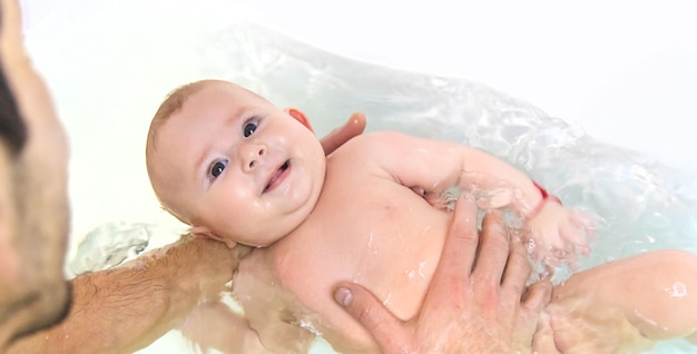 The father bathes the baby in the bath Selective focus