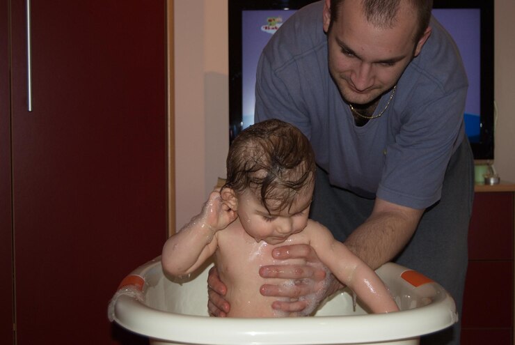 Photo father bathing baby boy