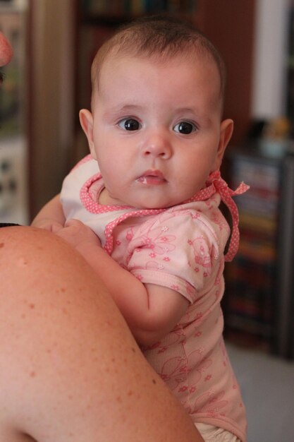 Photo father carrying cute girl at home