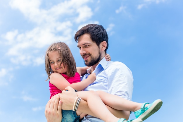 Father carrying daughter protecting her