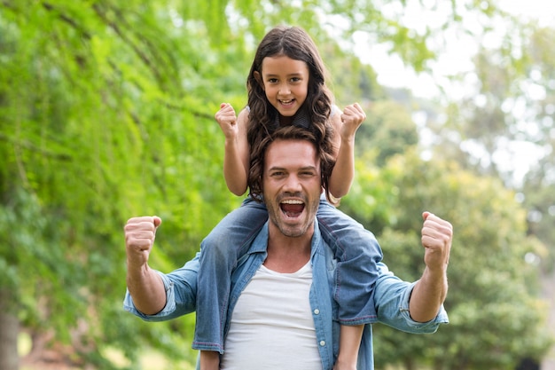 Father carrying her daughter on shoulder