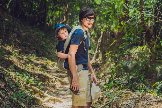 Father carrying his son on his back in nature