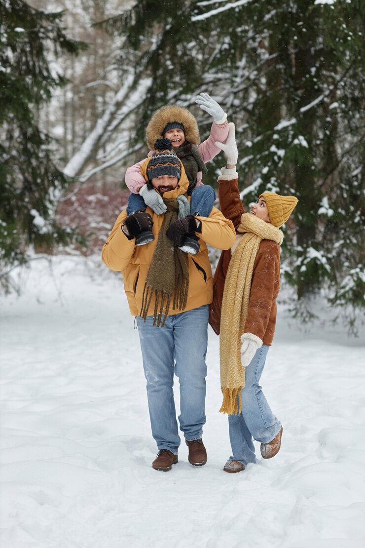 Photo father carrying smiling girl on shoulders in winter