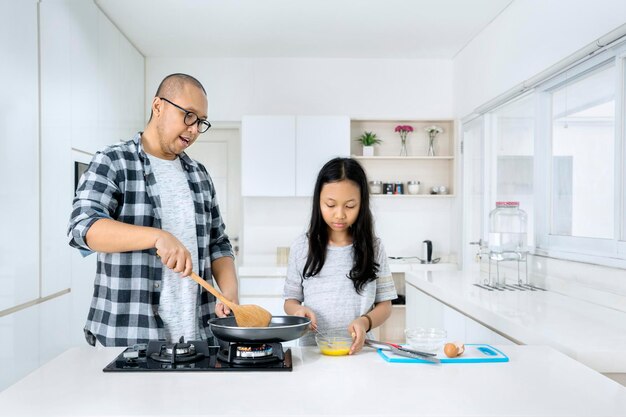 Father and child cooking together in kitchen