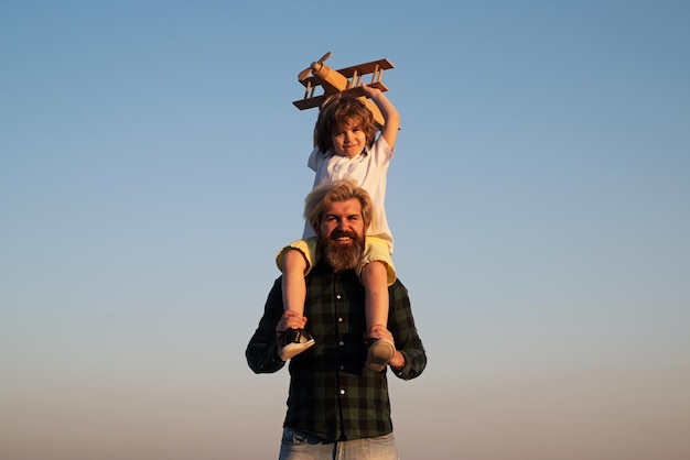 Father and child son playing outside Memories of childhood Child pilot aviator with airplane dreams