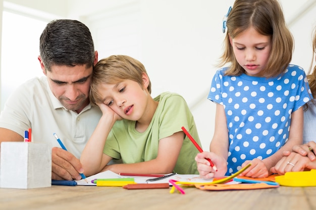 Padre e bambini che colorano