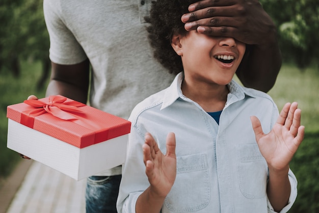 Father Closed his Eyes to Boy and Holds Box