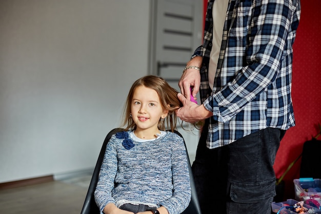 Father combing, brushing his daughter's hair at home