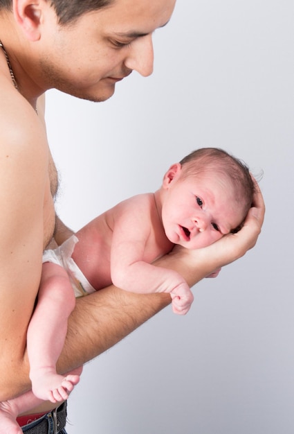 Father cuddling his new born baby in his hands