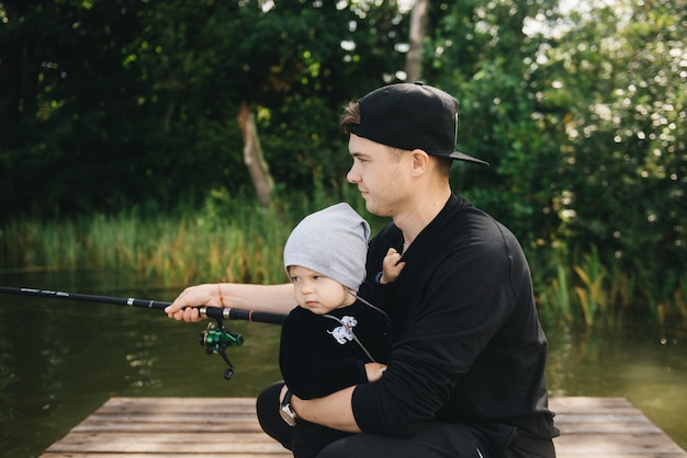 Father and cute son fishing in nature