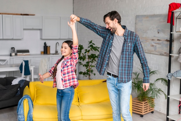 Father and daughter dancing in the living room