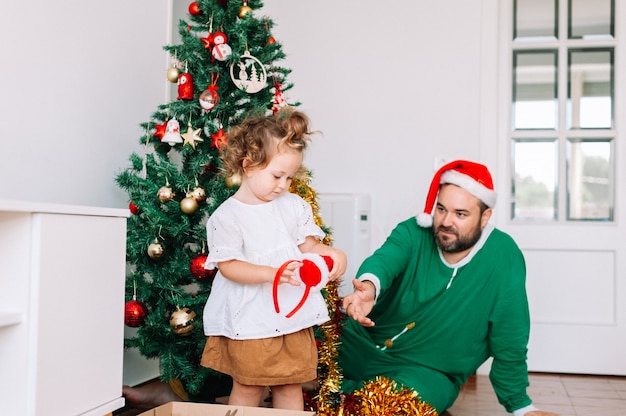 Father and daughter decorating Christmas tree