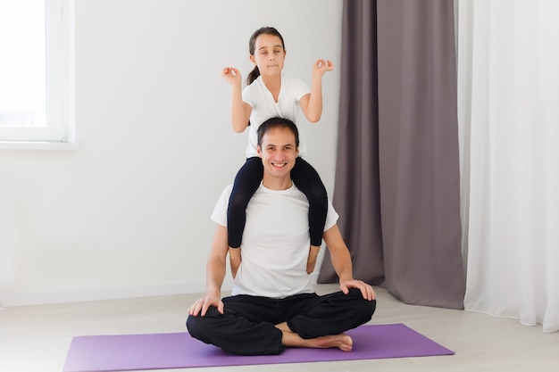 Father and daughter doing yoga at home