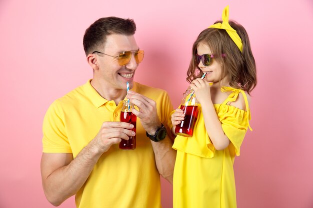 Father and daughter drinking red beverages and smiling