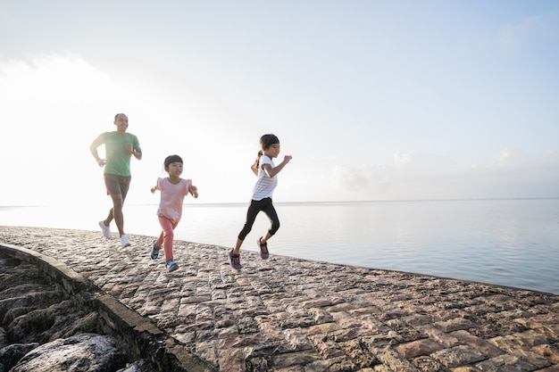 Father and daughter do exercises running outdoor racing each other