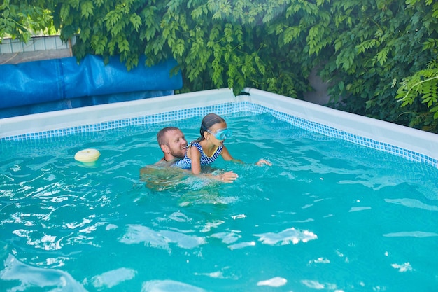 아버지와 딸은 집에서 수영장에서 즐거운 시간을 보냅니다.