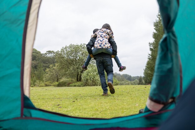 Father and daughter having fun at camp in the field