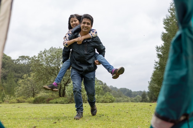 Father and daughter having fun at camp in the field