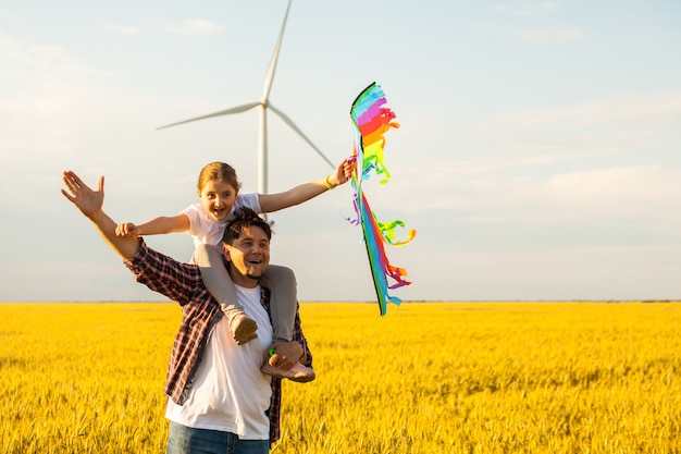 Father and daughter having fun, playing with kite together