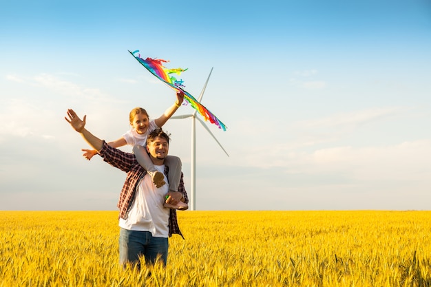 Father and daughter having fun, playing with kite together