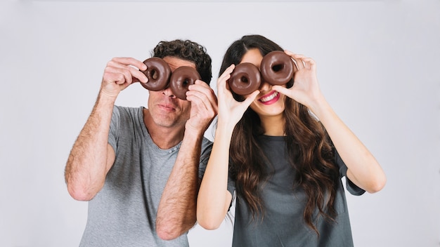 Father and daughter having fun with donuts