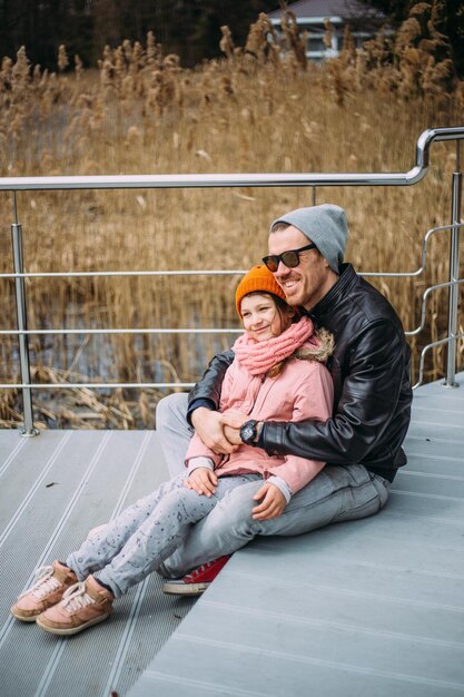 Father and daughter hug each other have fun and laugh outside in autumn