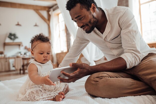 Photo father and daughter looking at digital tablet at home