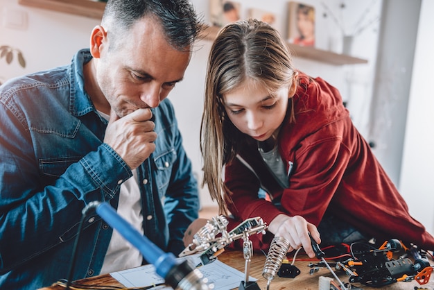 Father and daughter looking at electronic schematics