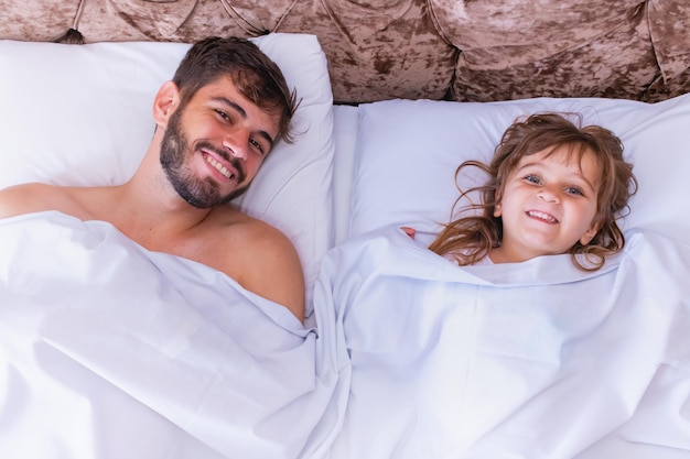 Father and daughter lying in bed