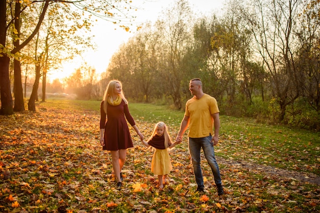 Father, daughter and mother walking outdoors. Happy family.