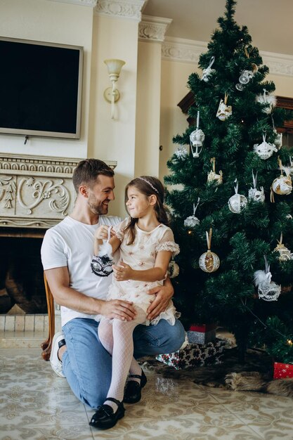 Father and daughter near the Christmas tree