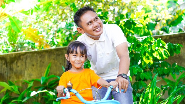 Father and daughter playing bicycles in the park