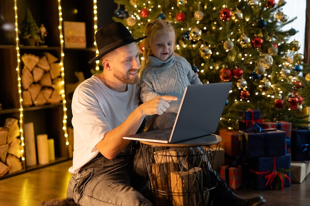 Photo father and daughter playing game on laptop computer. happy family time - modern lifestyle. christmas